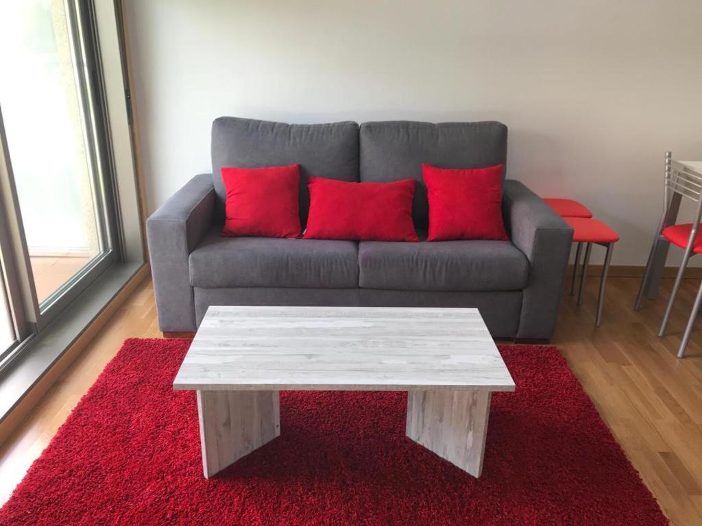 莫阿尼亚APARTAMENTO PLAYA A XUNQUEIRA的客厅配有红色枕头的沙发
