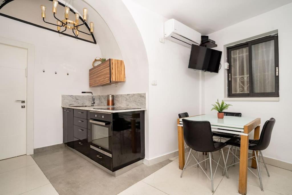 耶路撒冷Lovely 2 bedroom unit, Shivtey Israel, Jerusalem的厨房配有水槽和桌椅