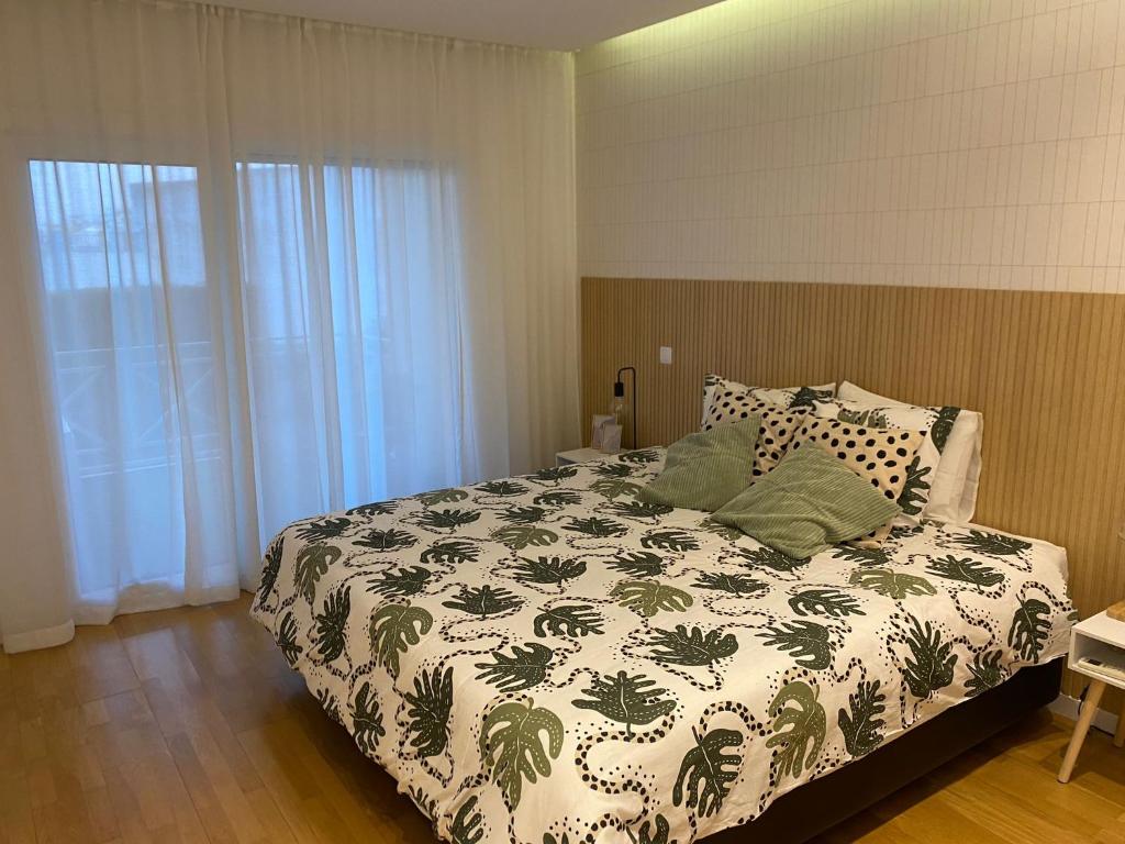 阿尔布费拉Garden Hill Apartment的一间卧室配有一张带绿色和白色棉被的床