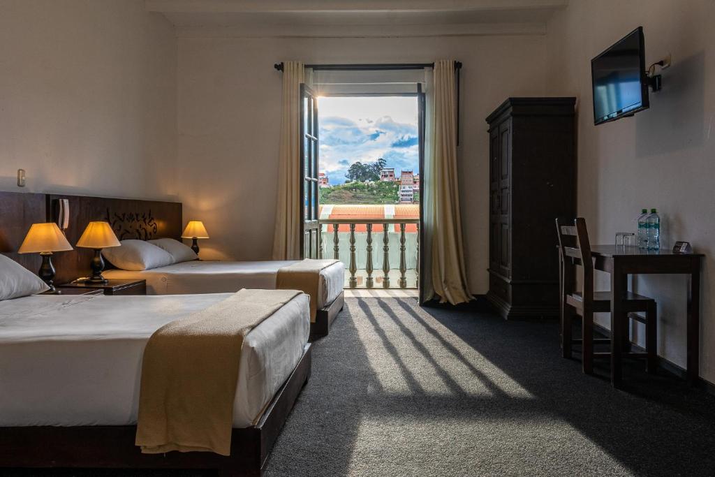 查查波亚斯La Xalca Hotel - Asociado Casa Andina的酒店客房设有两张床和大窗户。