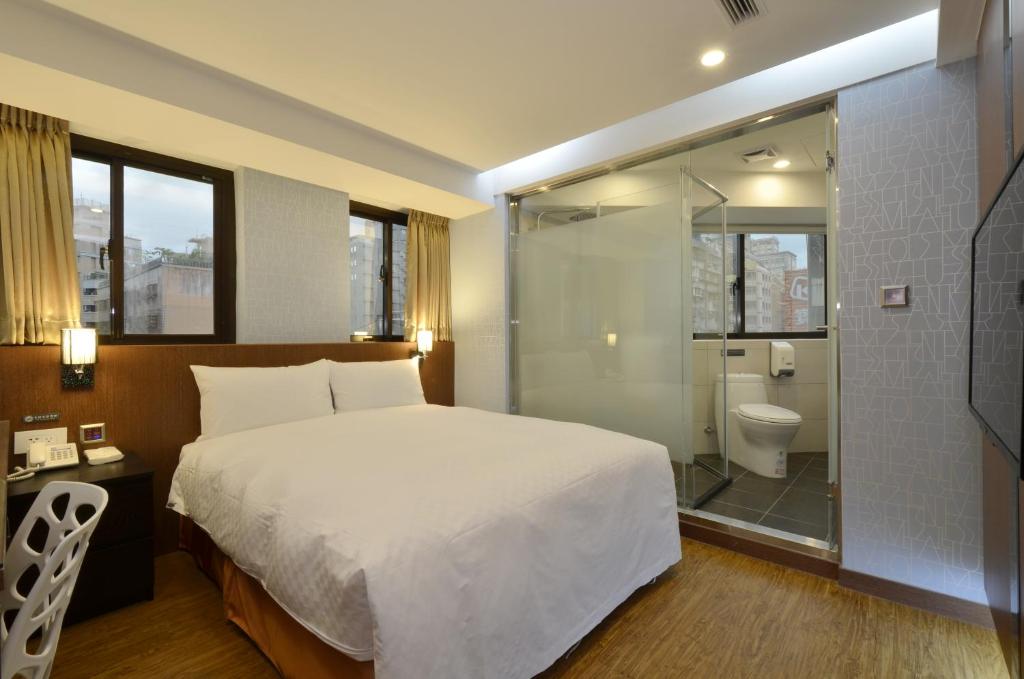 台北华大旅店-南西馆的一间卧室设有一张床、淋浴和卫生间