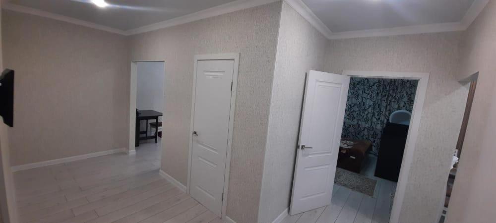 卡拉甘达Уютная квартира в новом ЖК Кристалл的一间空房间,有两个白色门和桌子