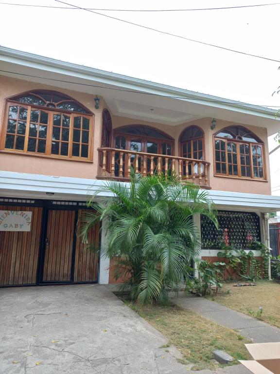 马那瓜Casa 114的前面有棕榈树的房子