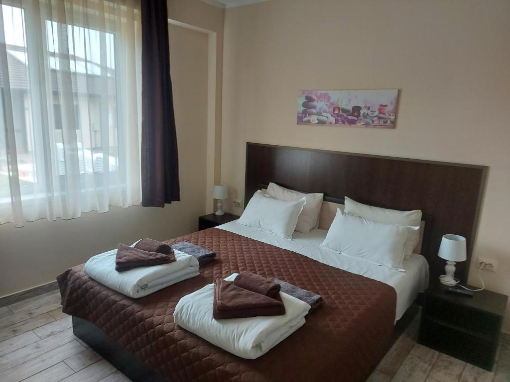 萨帕雷瓦巴尼亚Вилен комплекс Дарибел的一间卧室配有一张大床和两条毛巾