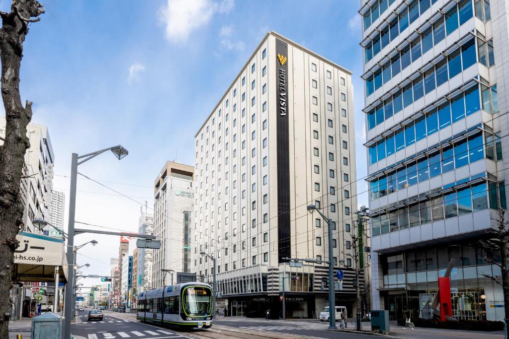 广岛Hotel Vista Hiroshima的一条城市街道上的公共汽车,有高高的建筑