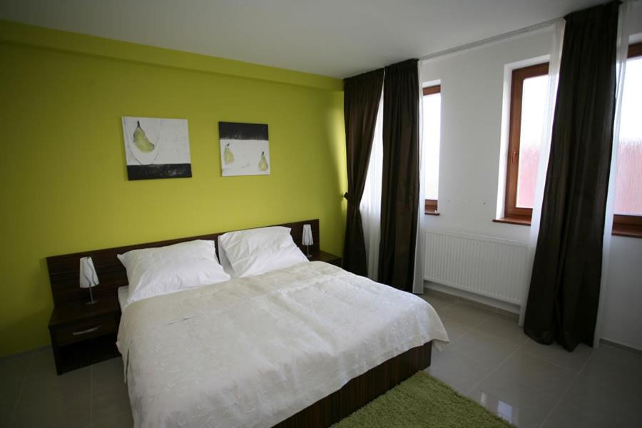 SládkovičovoGrand hotel/pension的卧室配有白色的床和绿色的墙壁