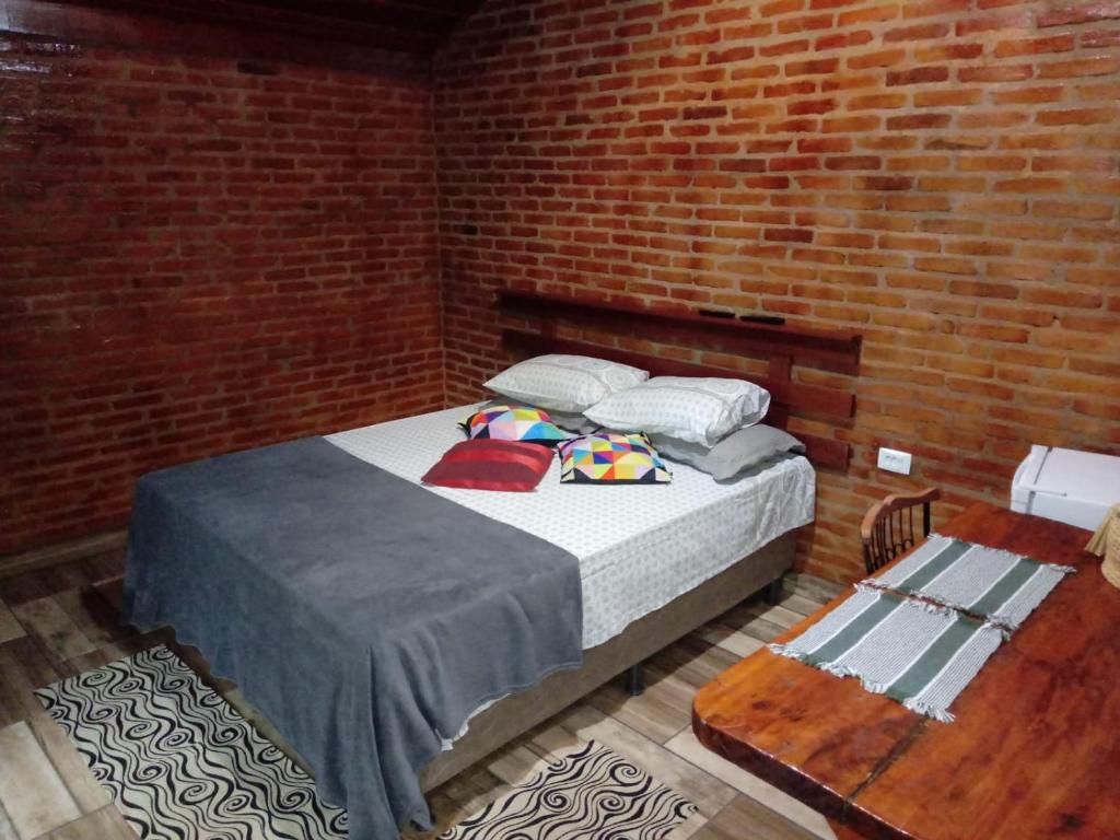 布埃诺布兰当Chalés Pedacim du Céu的卧室配有砖墙内的床铺