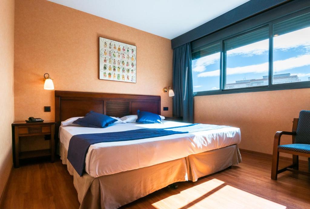 富恩拉夫拉达Hotel Las Provincias的一间卧室设有一张床和一个大窗户