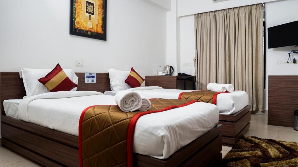 GhansoliThe Altruist Business Stays, Navi Mumbai-2的酒店客房设有两张床和电视。