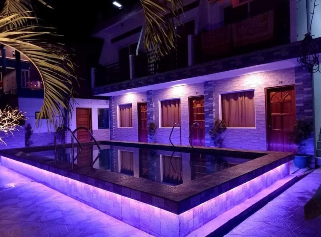 卢纳将军城Foxtail Siargao Island Guesthouse的一座晚上设有游泳池的房子