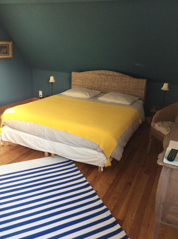 勒克罗图瓦La VILLA en BAIE的一间卧室配有一张带黄色毯子的大床