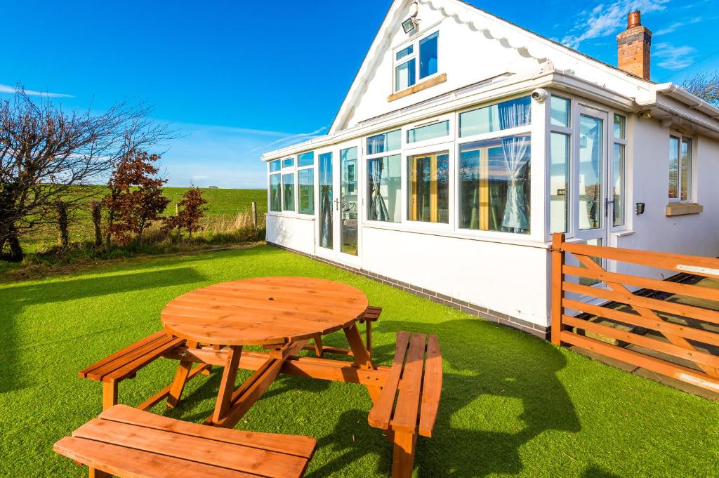 Bodelwyddan"Woodlands" by Greenstay Serviced Accommodation - Luxury 3 Bed Cottage In North Wales With Stunning Countryside Views & Parking - Close To Glan Clwyd Hospital - The Perfect Choice for Contractors, Business Travellers, Families and Groups的野餐桌和两把椅子位于房子前面