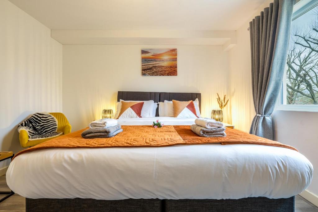 斯坦斯Ashview 2 - Heathrow - Thorpe Park - Free Parking的一间卧室配有一张大床和毛巾