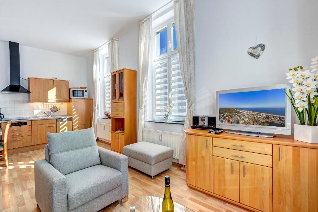 赛巴特班森Villa Frieda Wohnung 6的客厅配有椅子和电视