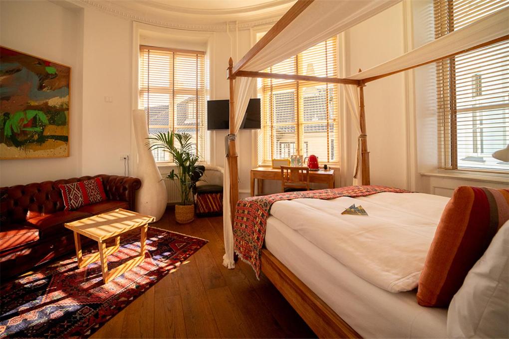 哥本哈根巴贝特古尔德斯梅登酒店的一间卧室配有一张床和一张沙发