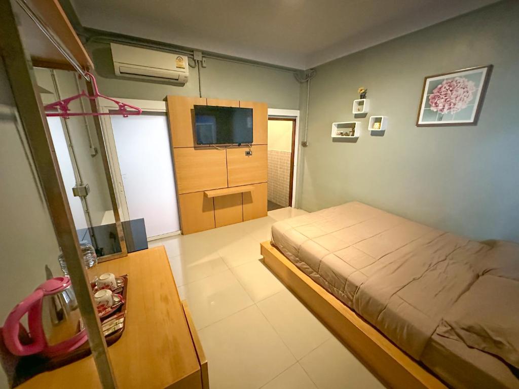 清迈Baan Chiang Maan的一间卧室配有一张床和一台电视