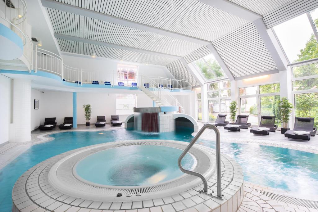 戈斯拉尔阿施特曼酒店的大楼内带热水浴池的大型游泳池