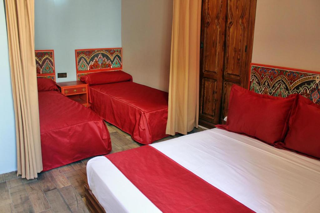 丹吉尔马兰汽车旅馆的一间酒店客房,配有两张床和红色枕头