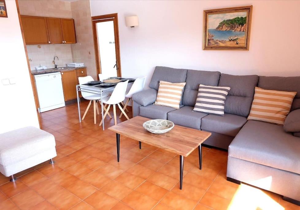 卡莱利亚德帕拉弗鲁赫尔Apartamento con piscina L' Áncora的客厅配有沙发和桌子