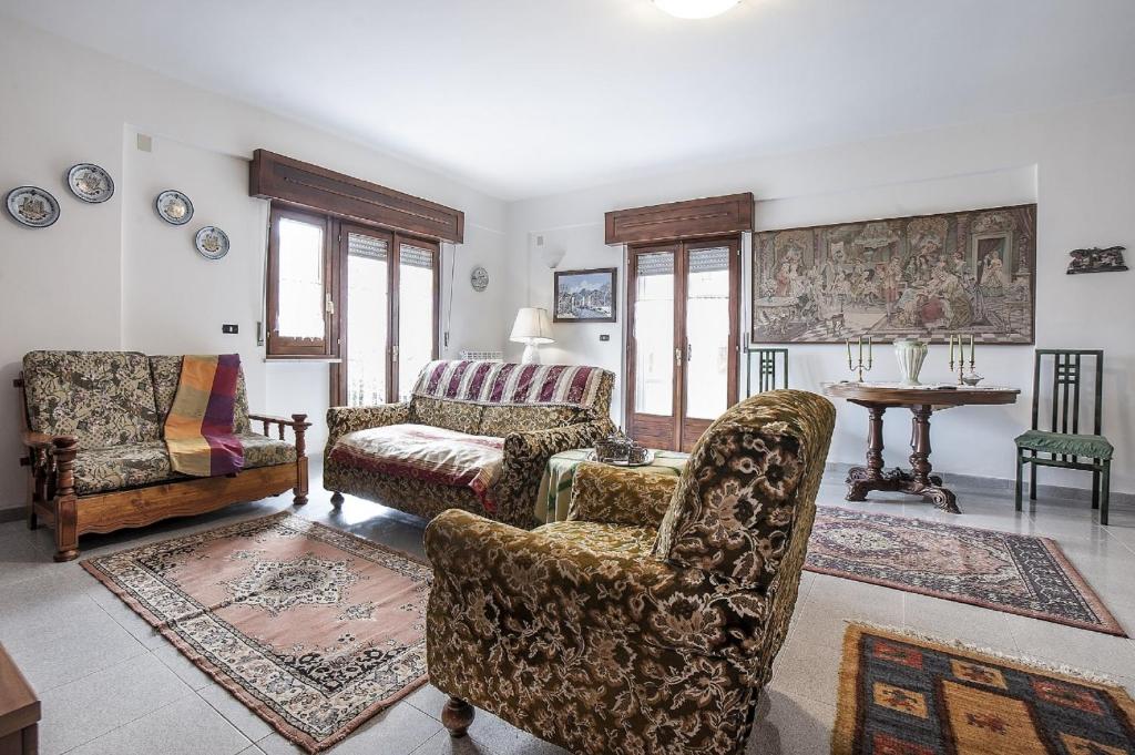 Sant’AngeloPassiflora House - Basilicata的客厅配有两把椅子和一张沙发