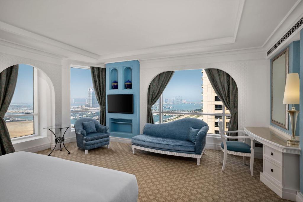 迪拜傲途格精选酒店旗下哈布图尔格兰德度假村的一间卧室配有一张床、两把椅子和一个窗户