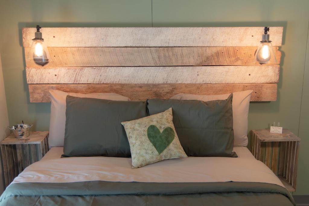 KingsvilleThe Green Heart Inn的一张带木制床头板和枕头的床