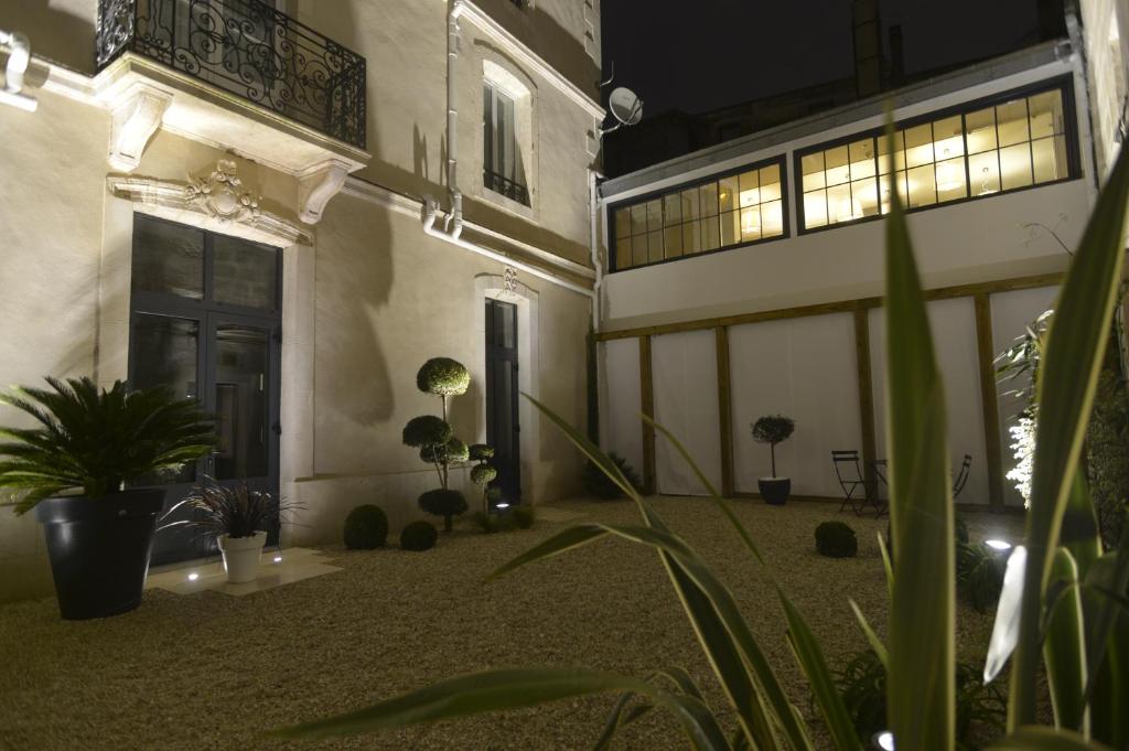 尼奥尔法国酒店的一座空旷的庭院,里面种有盆栽植物,有一扇门