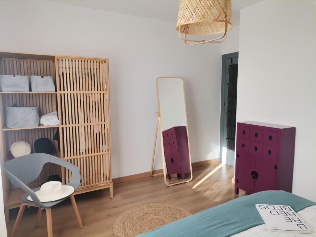 阿尔梅利马Villa Pepita的一间卧室配有一张床、一把椅子和镜子