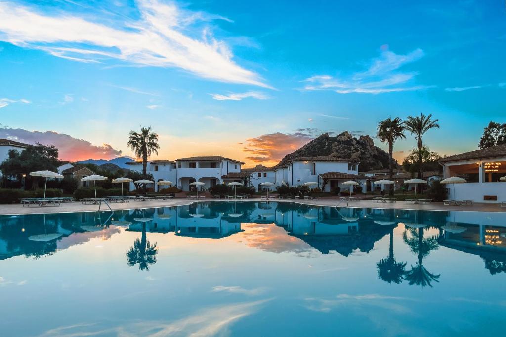 圣玛丽亚纳瓦雷Marina Torre Navarrese Resort的日落时欣赏度假村的游泳池景致
