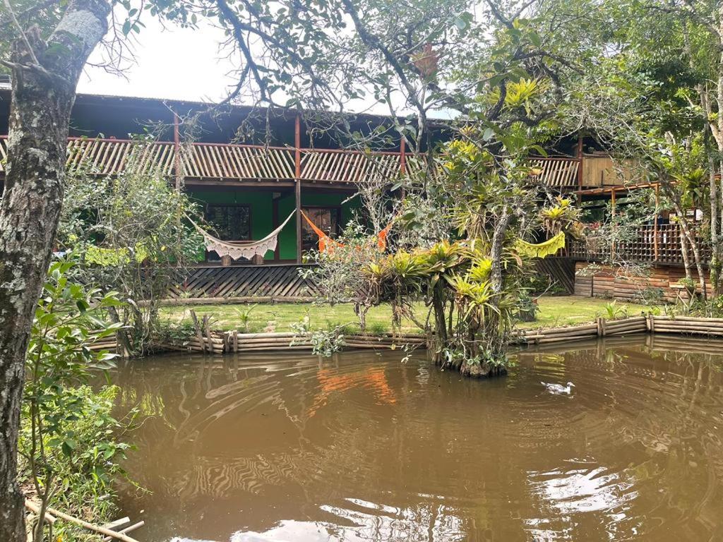 帕拉蒂Pousada Meraki Paraty Mirim的前面有池塘的房子