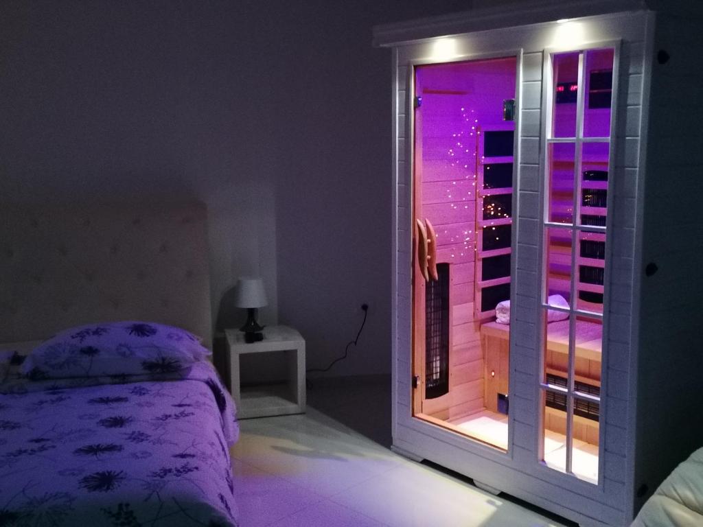 科佩尔VILA MOLET KOPER的一间卧室配有一张床和一个带紫色灯的窗户
