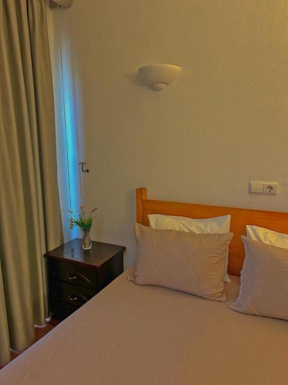 卡帕里卡海岸Copacabana Residencial的一间卧室配有一张带两个枕头和一张桌子的床。