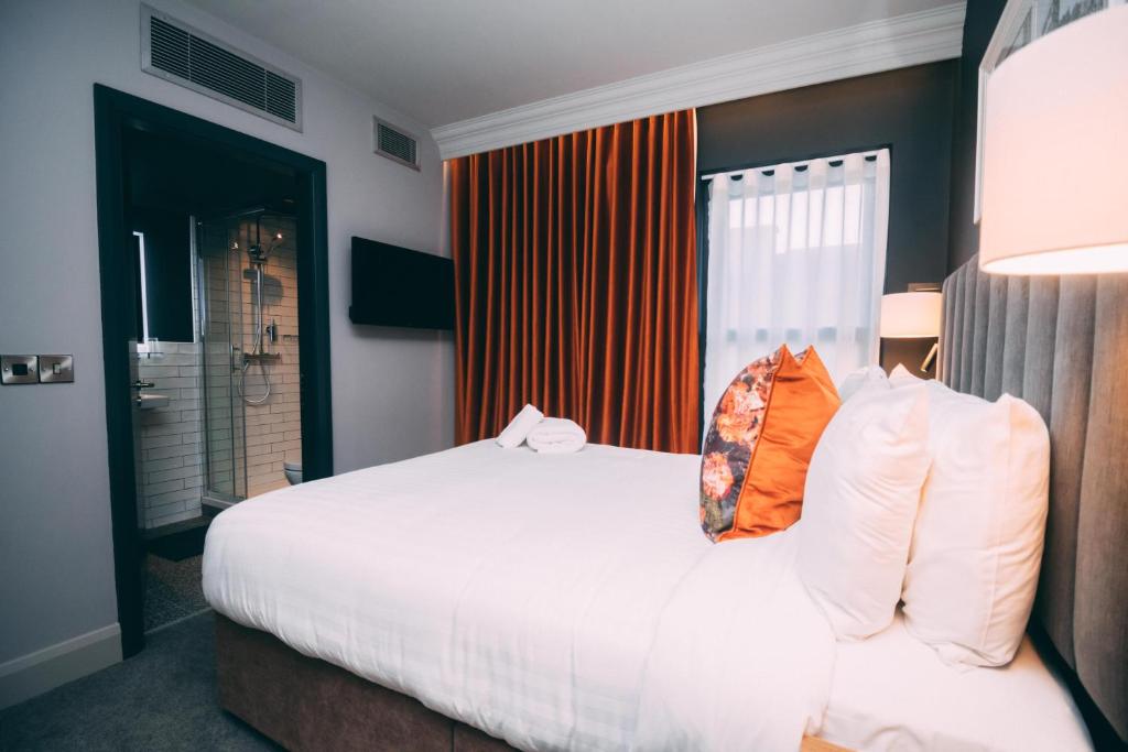 都柏林Thomas Moore Inn的卧室配有带橙色枕头的大型白色床