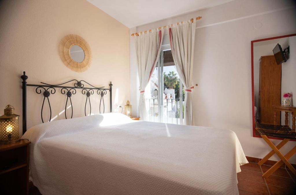 萨各夫雷纳圣胡安旅馆的卧室配有白色的床和窗户。