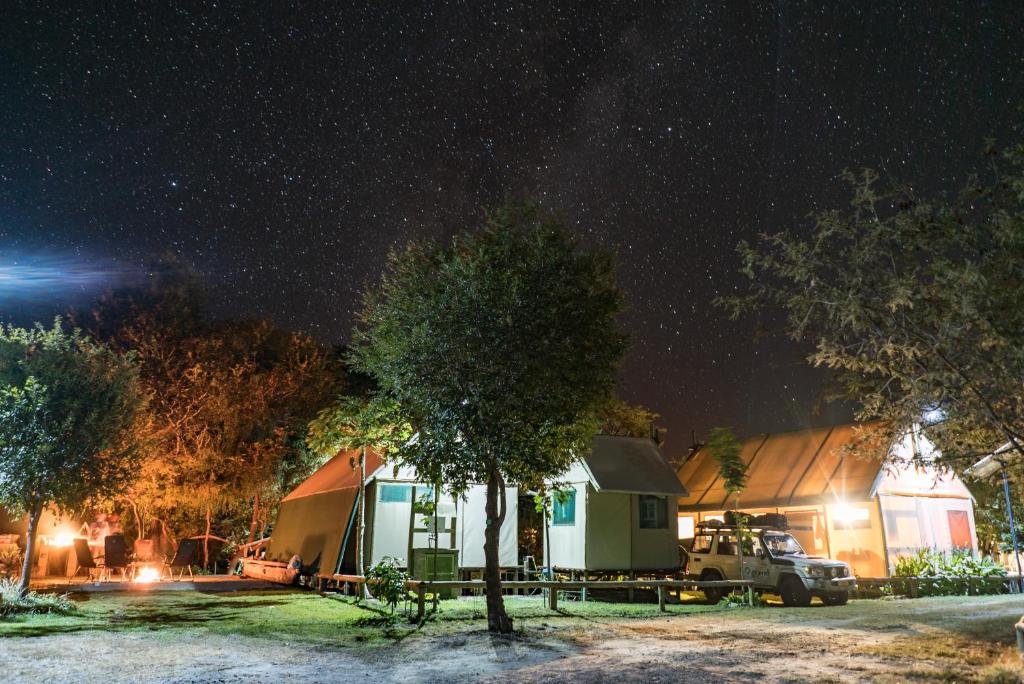 卡蒂马穆利洛Kubu & Kwena Lodge的停在大楼前的帐篷和卡车