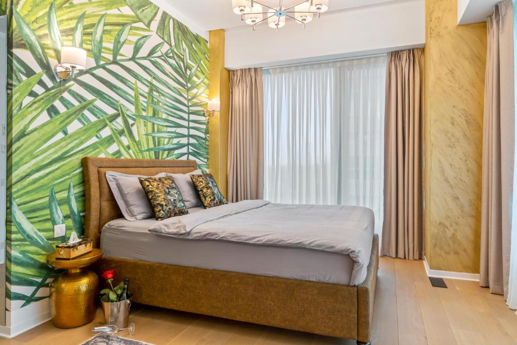 布加勒斯特ONE Tower Apartments的一间卧室配有一张热带壁画床