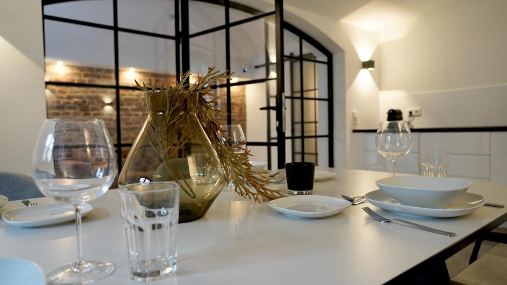 伍珀塔尔Luxuriöse Stadtvilla im Hansaviertel的一张带玻璃杯和盘子的白色桌子