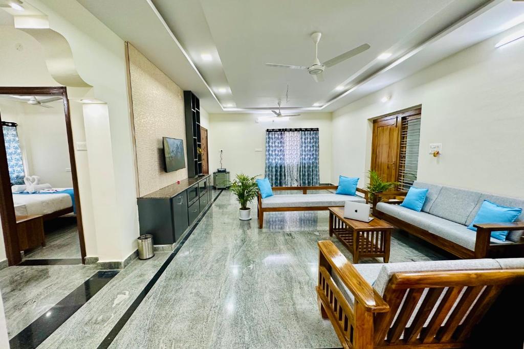 蒂鲁帕蒂TrueLife Homestays - Bhavya Manor - 2500 SFT Modern homes for family stay - Garden with Flowers - Tirumala Mountain View - Peaceful Location - Many restaurants nearby - Large hall, AC bedrooms, Modular Kitchen - Fast WiFi - Android TV - 250 Jio Channels的带沙发的客厅和客厅。