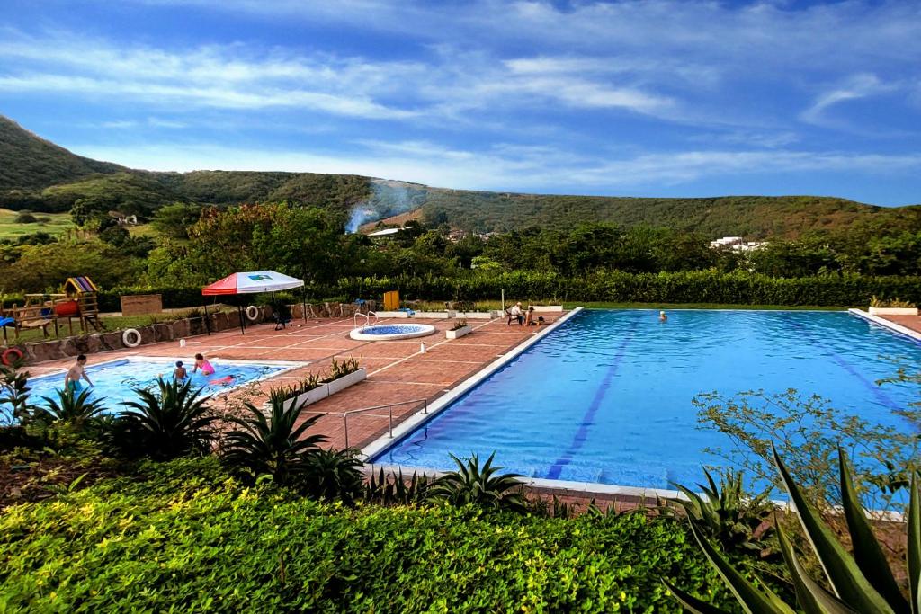 阿纳波伊马Casa de Encanto Vacacional con piscina en Anapoima, condominio privado hasta 9 personas的一座大游泳池,后面是一座山
