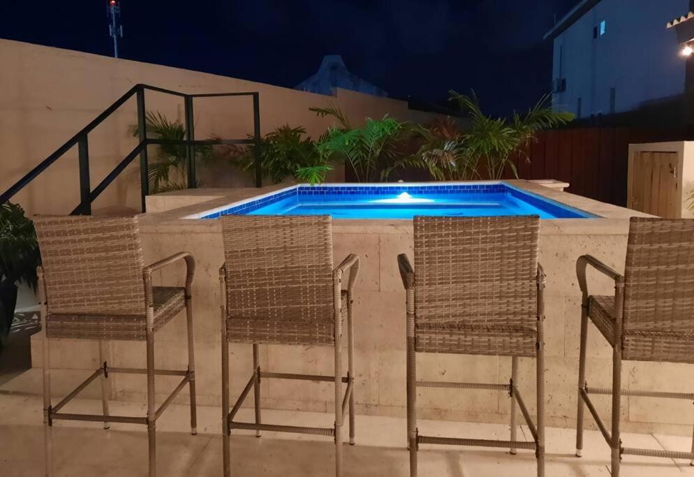 棕榈滩Ojanea Home的一组椅子和一个游泳池