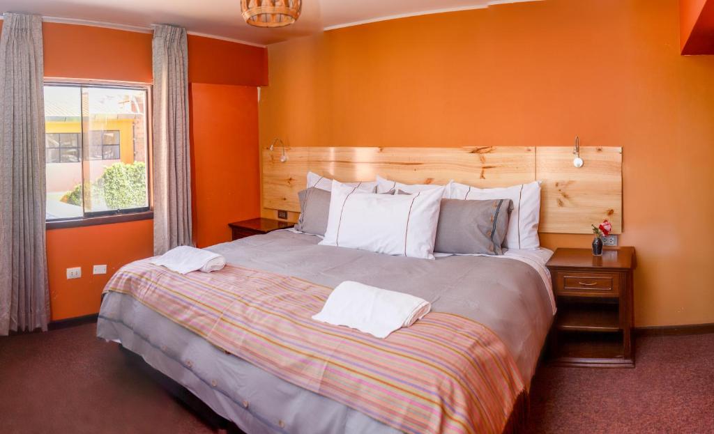 奇瓦伊Colibrí Inn的一间卧室配有一张带橙色墙壁的大床