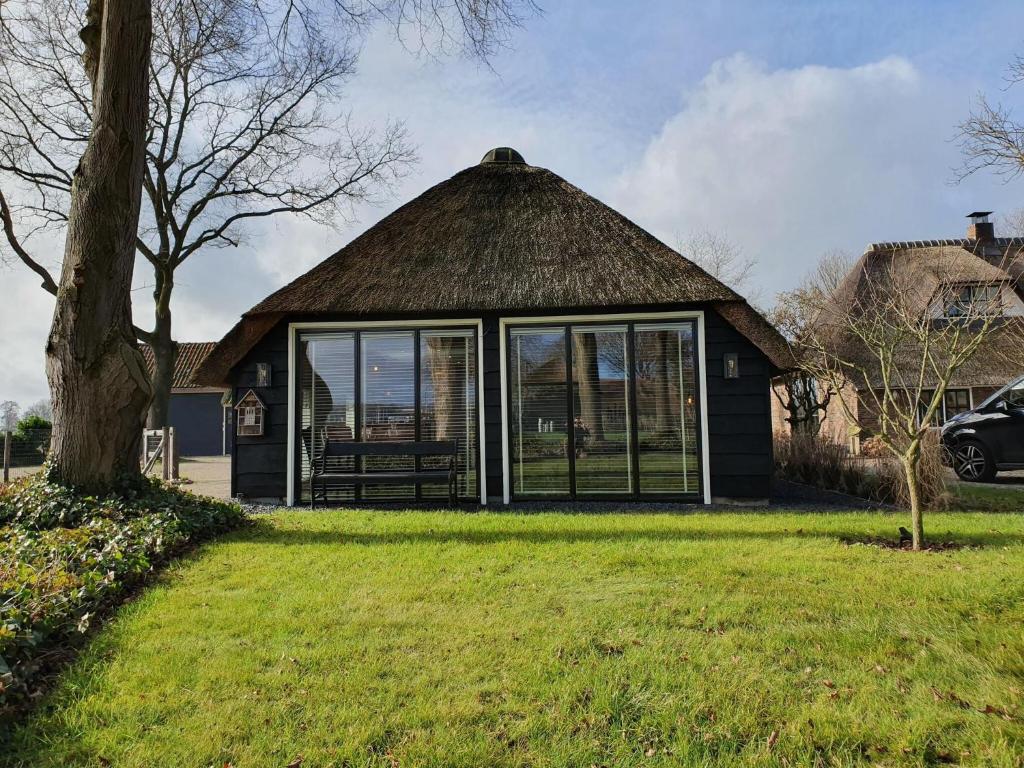 De MeeleCozy holiday home in Overijssel in a wonderful environment的茅草屋顶房屋,带庭院