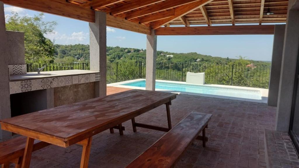 阿瓜德奥罗La Pasionaria Casa de Campo的一个带木桌和游泳池的庭院