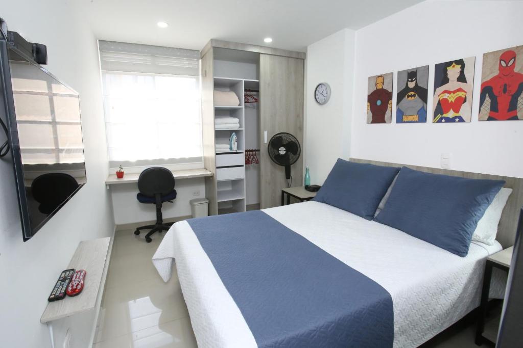 麦德林New Studio Apartment for Two的卧室配有蓝色和白色的床和书桌。