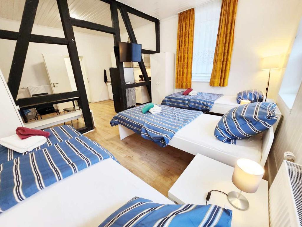 布尔沙伊德1 Room Apartment in Burscheid的一间设有三张蓝色和白色床铺的房间