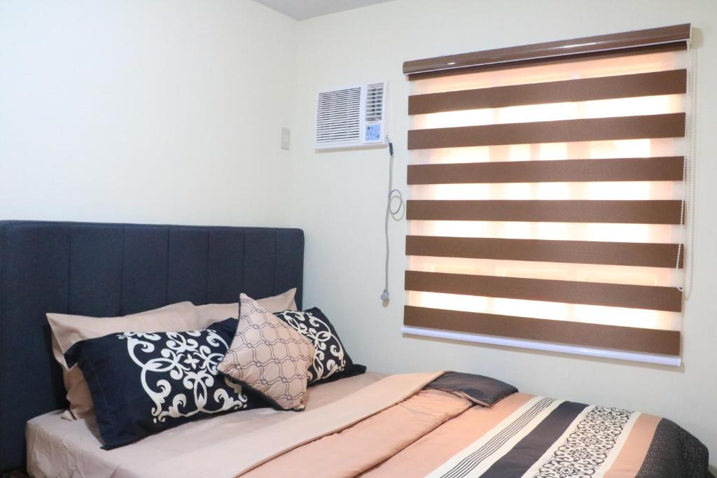 马尼拉Anicia Guesthouse Rooms的卧室配有带枕头的床铺和窗户。