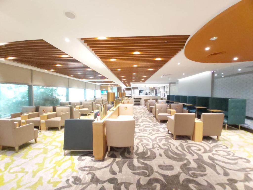 新加坡3号航站楼大使过境休息室酒店的大楼内带桌椅的等候室