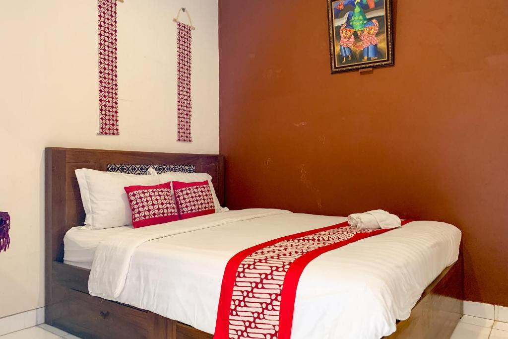 日惹Grha Vege Jawi Syariah Mitra RedDoorz的一间卧室配有两张带红白色枕头的床