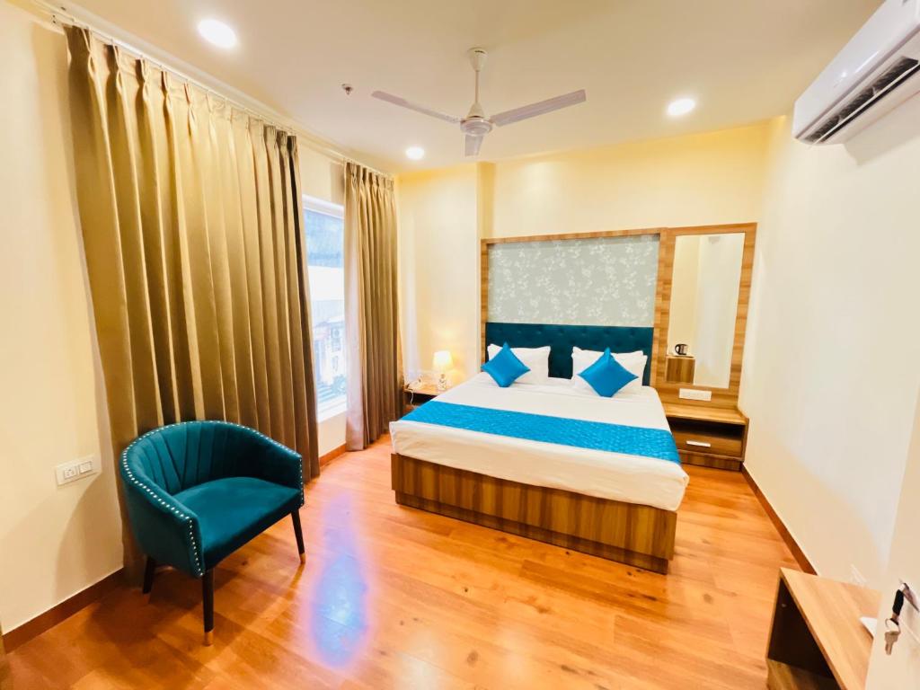 阿姆利则Hotel The Orchid Tree Amritsar - walking from Golden Temple的一间卧室配有一张床和一张蓝色椅子