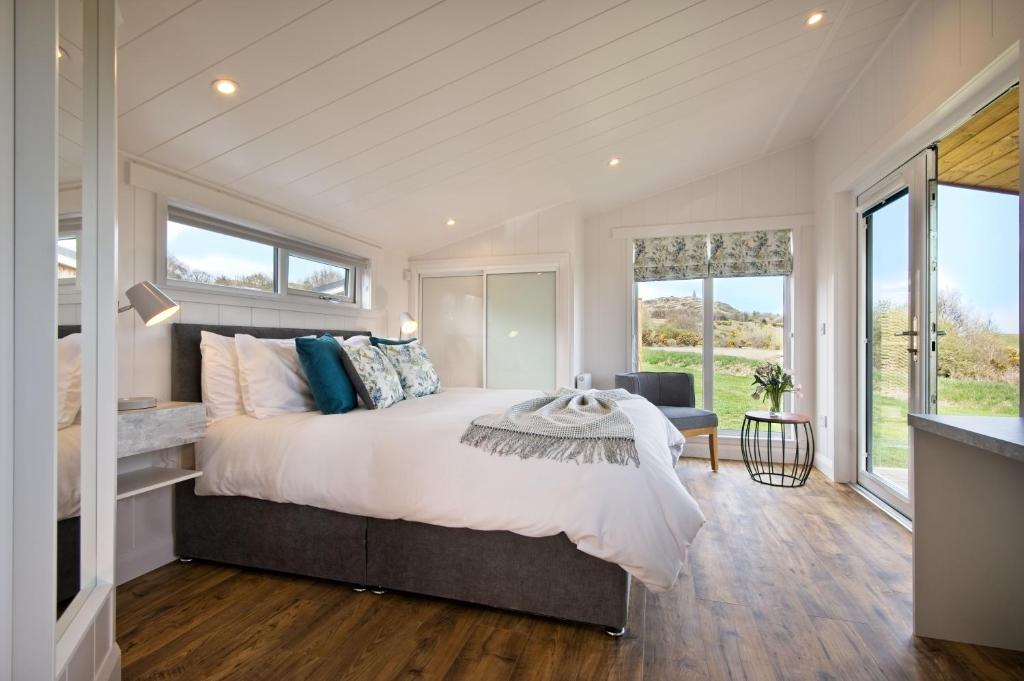 RingfordThe Pond Lodges Barstobrick的一间卧室设有一张大床和大窗户